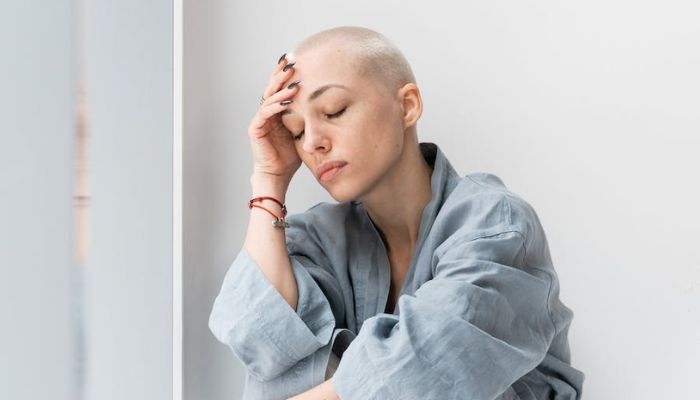 Unhappy cancer patient with headache and closed eyes.— Pexels