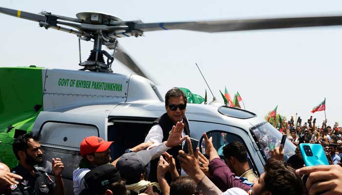 PTI Chairman Imran Khan waves at supporters as he disembarks from a helicopter to lead a protest rally in Swabi on May 25, 2022. — AFP