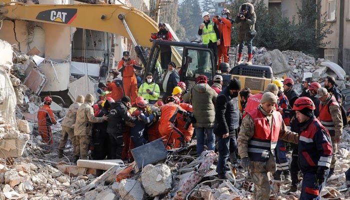 Turkish and Chinese rescuers carry Malek, a 55-year-old Syrian refugee man, into an ambulance after he was rescued from the wreckage of a destroyed building in Hatay, Turkey on February 12, 2023. Reuters