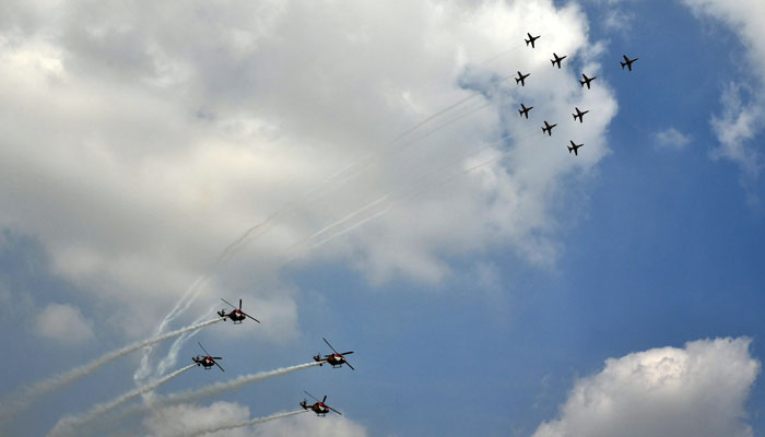 Indian Air Force's Sarang helicopter and Suryakiran aerobatic team perform during the Aero India 2021 Air Show at Yelahanka Airport on February 3, 2021 in Bengaluru, India.  - Reuters