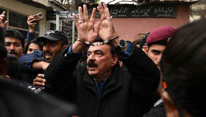 Police officials escort Pakistans former interior minister Sheikh Rashid Ahmed (centre) to present him before a court in Islamabad on February 2, 2023. — AFP