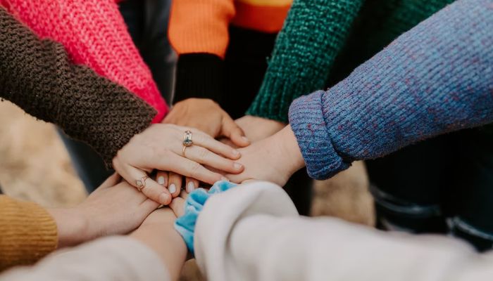 Womens hands piled together.— Unsplash