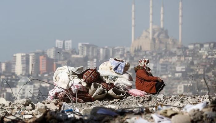 A woman sits on the rubble of her house in the aftermath of a deadly earthquake in Kahramanmaras, Turkey February 14, 2023.— Reuters