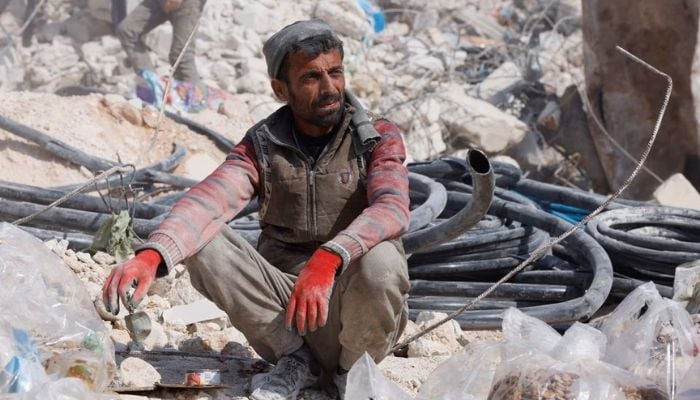 A man sits atop rubble, in the aftermath of a deadly earthquake in the rebel-held town of Harem, in Idlib governorate, Syria, February 14, 2023.— Reuters