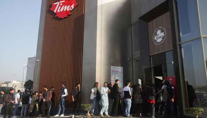 People wait for their turn to get in Tim Hortons Cafe and Bake Shop, in Lahore, Pakistan, February 14, 2023. — Reuters