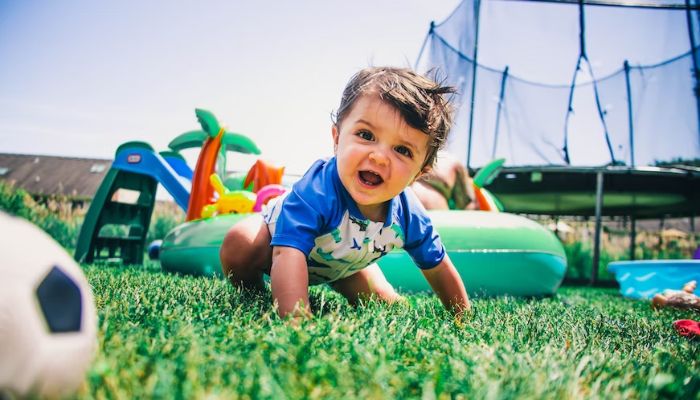 A baby boy plays in the garden.— Unsplash