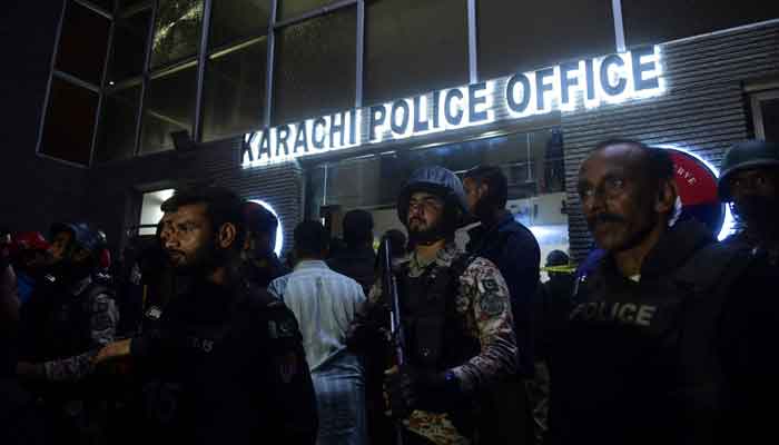 Security personnel stand guard outside the Karachi Police Office after it was attacked by terrorists on February 17, 2023. — AFP