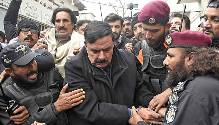 Police officials escort Chief of Awami Muslim League (AML) and former Interior Minister Shiekh Rashid as he arrives to attend hearing at additional and sessions court in Islamabad on February 2, 2023. — Online