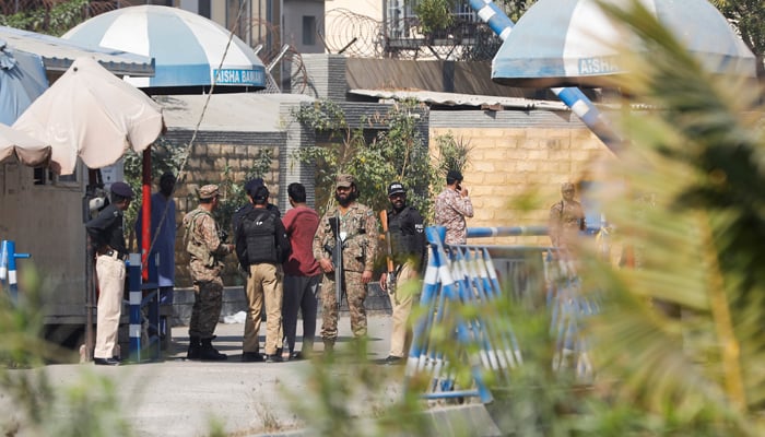 Army soldiers secure the area along with police officers after yesterdays attack on a police station, in Karachi on February 18, 2023. — Reuters