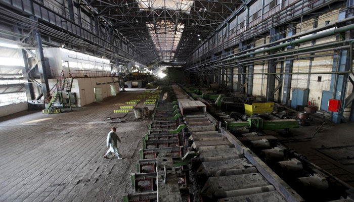A man walks past machines at the hot strip mill department of the Pakistan Steel Mills on the outskirts of Karachi on February 8, 2016. — Reuters