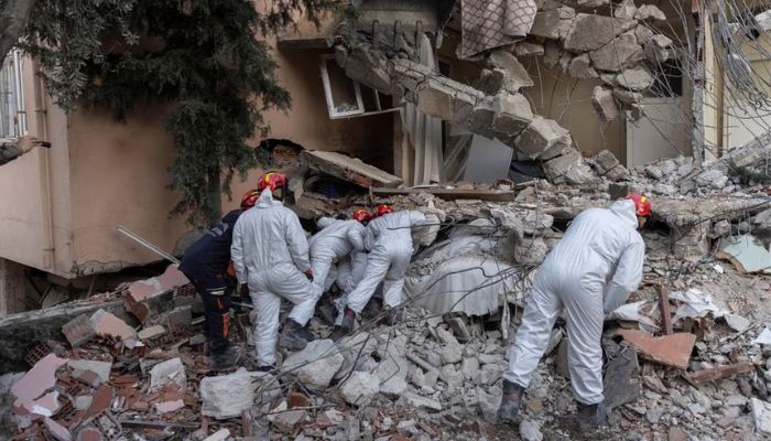 A search team look through the cracks in the rubble of a house as they look for missing persons Leyla Habip and Nejat Habip in the aftermath of the deadly earthquake, in Hatay, Turkey, February 18, 2023.— Reuters