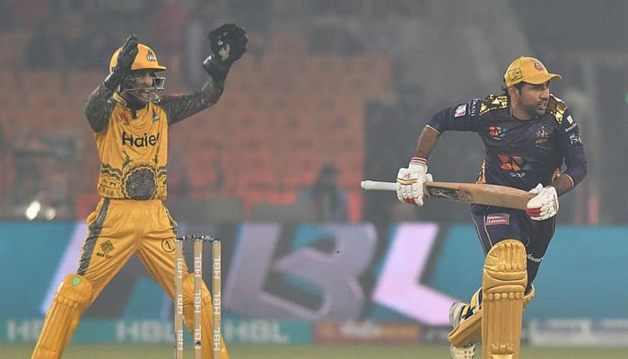 A Quetta Gladiators batter runs while a Peshawar Zalmi wicketkeeper prepares to catch the ball during a match between the two teams in the seventh season of Pakistan Super League in 2022. — PSL/ File
