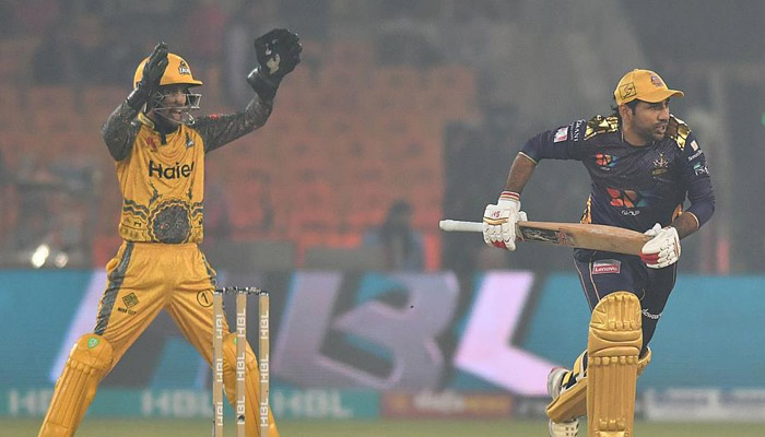 A Quetta Gladiators batter runs while a Peshawar Zalmi wicketkeeper prepares to catch the ball during a match between the two teams in the seventh season of Pakistan Super League in 2022. — PSL/ File