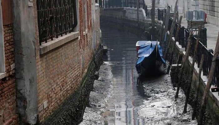 A gondola is pictured in a canal during a severe low tide in the lagoon city of Venice, Italy, February 17, 2023. Reuters