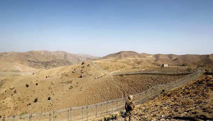 A Pakistani soldier stands guard along the border fence outside an outpost on the border with Afghanistan in North Waziristan, Pakistan. — Reuters/File