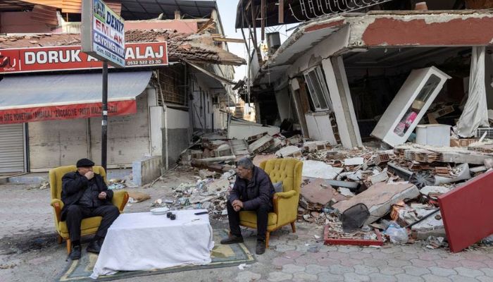 Men sit and talk in front of destroyed properties in the aftermath of the deadly earthquake in Antakya, Hatay province, Turkey, February 20, 2023.— Reuters