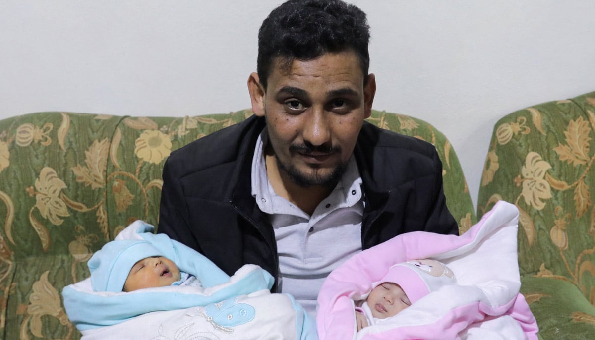 Afraas uncle-by-marriage, Khalil Al-Sawadi, holds her and (right) his own newborn daughter, in Jandaris, Syria February 18, 2023. — Reuters