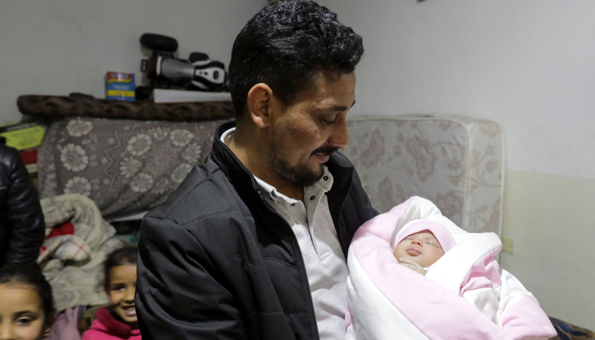 Khalil Al-Sawadi, Afraas uncle-by-marriage holds her, in rebel-held town of Jandaris, Syria February 18, 2023.— Reuters