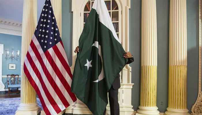 A State Department contractor adjusts a Pakistan national flag before a meeting between U.S. Secretary of State John Kerry and Pakistans Interior Minister Chaudhry Nisar Ali Khan on the sidelines of the White House Summit on Countering Violent Extremism at the State Department in Washington February 19, 2015. — Reuters