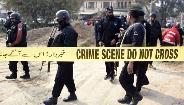 Armed policemen standing at a crime scene during an investigation in this undated photo. — Online/File