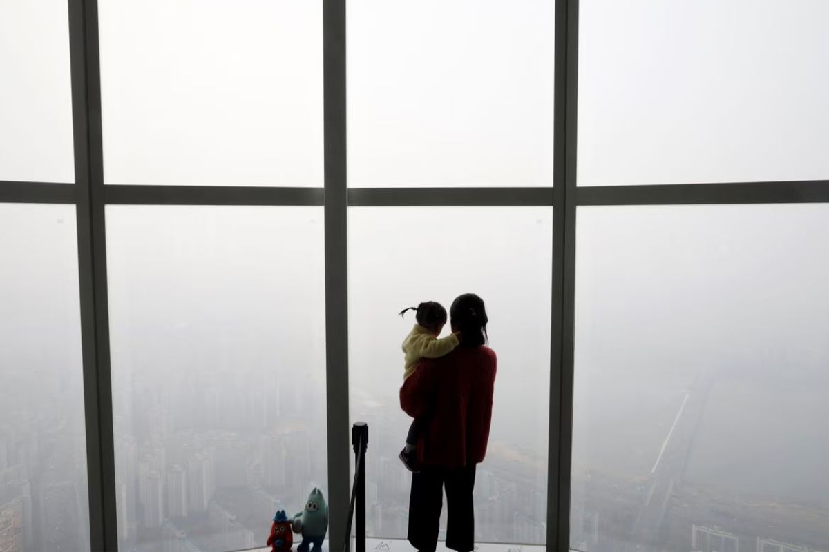 A woman holding her baby in her arms looks at a view of Seoul shrouded by fine dust during a polluted day in Seoul, South Korea, March 6, 2019.— Reuters