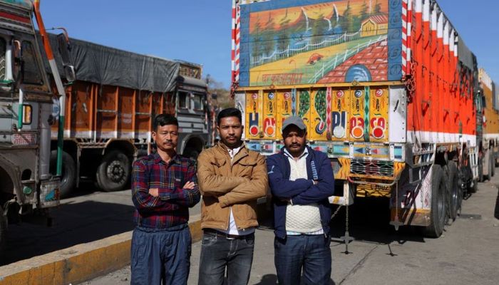 Truck drivers Lal Singh, Vijay Mehra and Tilak Raj pose for a picture near parked trucks next to the Ambuja Cements Limited plant owned by Adani Group in Darlaghat, Solan district in the state of Himachal Pradesh, India, February 16, 2023.— Reuters