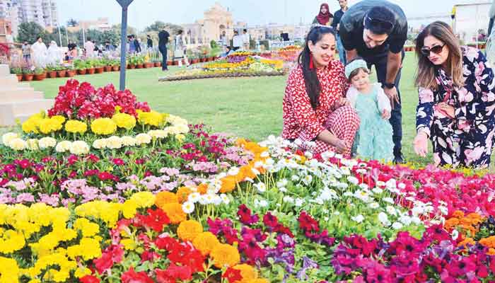 The picture shows a family enjoying Annual Flower Show in Karachi on February 23, 2023. — The News