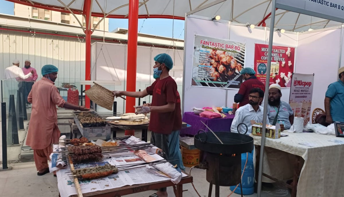 A chef fans burning coals at a barbecue station during the second day of the Bohra Food Festival in Karachi. — By the author