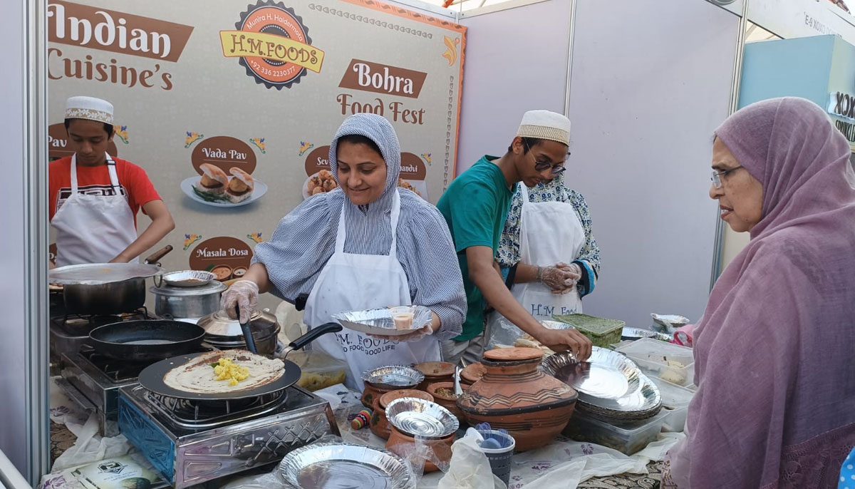 A woman food vendor prepares traditional food for a customer during the second day of the Bohra Food Festival in Karachi. — By the author