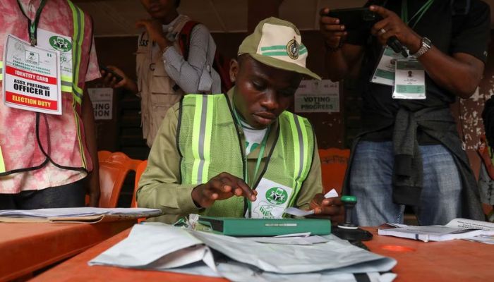 A member of the National Youth Service Corps (NYSC) operates a Bimodal Voter Accreditation System (BVAS) during Nigerias Presidential election in Agulu, Anambra state, Nigeria February 25, 2023.— Reuters