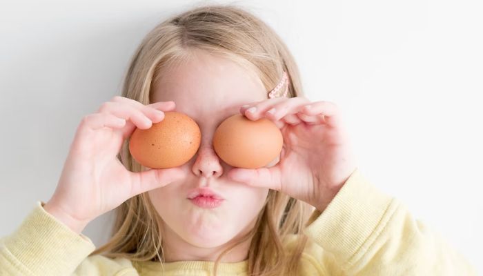 A girl holding two eggs.—Unsplash