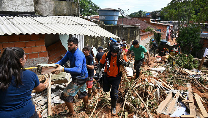 People remove debris at a flood-affected area in Barra do Sahy, Sao Sebastiao district, Sao Paulo state, Brazil on February 21, 2023. AFP