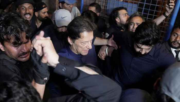پاکستان کے سابق وزیر اعظم عمران خان اپنے حامیوں کے ساتھ 20 فروری 2023 کو لاہور، پاکستان میں ایک عدالت سے باہر نکل رہے ہیں۔ - رائٹرز