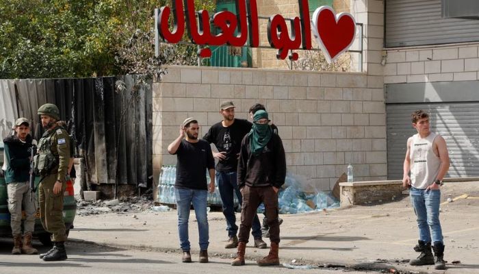 Israeli settlers stand next to an Israeli member of the military, in the aftermath of an incident where a Palestinian gunman killed two Israeli settlers, near Hawara in the Israeli-occupied West Bank, February 27, 2023.— Reuters