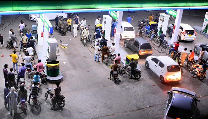 A large number of bike and car owners stand in a queue at a petrol pump in Hyderabad on July 2, 2022. — APP