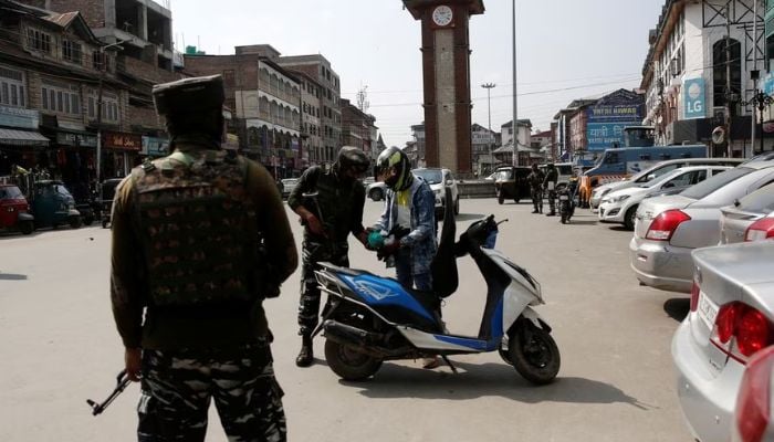 Indian Central Reserve Police Force (CRPF) personnel check the bags of a scooterist as part of security checking in Srinagar, October 12, 2021.— Reuters