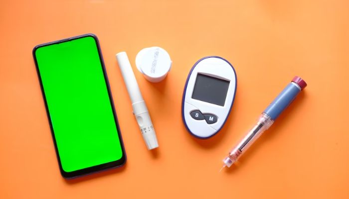 Insulin pen, diabetic measurement tools a smartphone with empty space on the table.— Unsplash