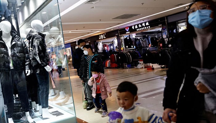 Customers shop at a mall ahead of the Chinese Lunar New Year, in Beijing, China January 15, 2023. REUTERS/File