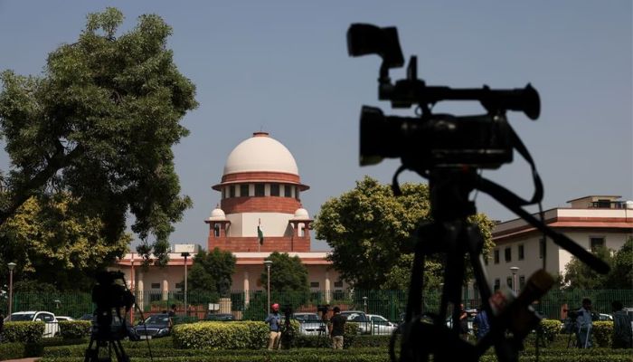 Members of media speak in front of cameras outside the premises of the court in New Delhi, India October 13, 2022.— Reuters