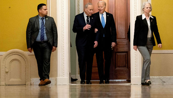 US President Joe Biden talks with Senate Majority Leader Chuck Schumer (D-NY) as he arrives for the Senate Democratic Caucus policy luncheon at the US Capitol in Washington, DC, on March 2, 2023. AFP