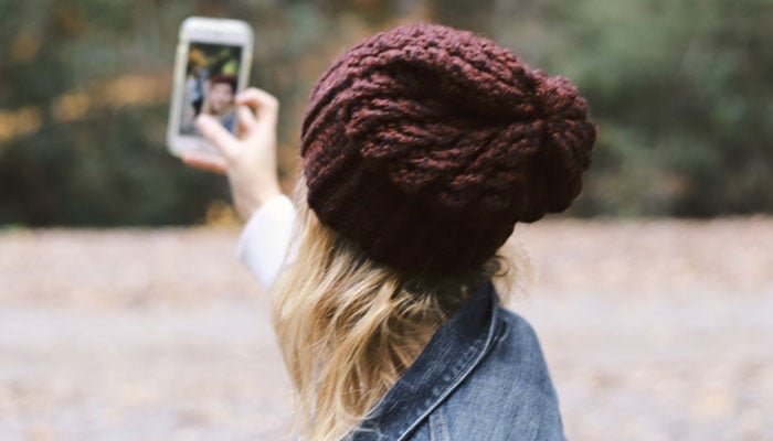 A girl is seen capturing a selfie. representational image from Unsplash.