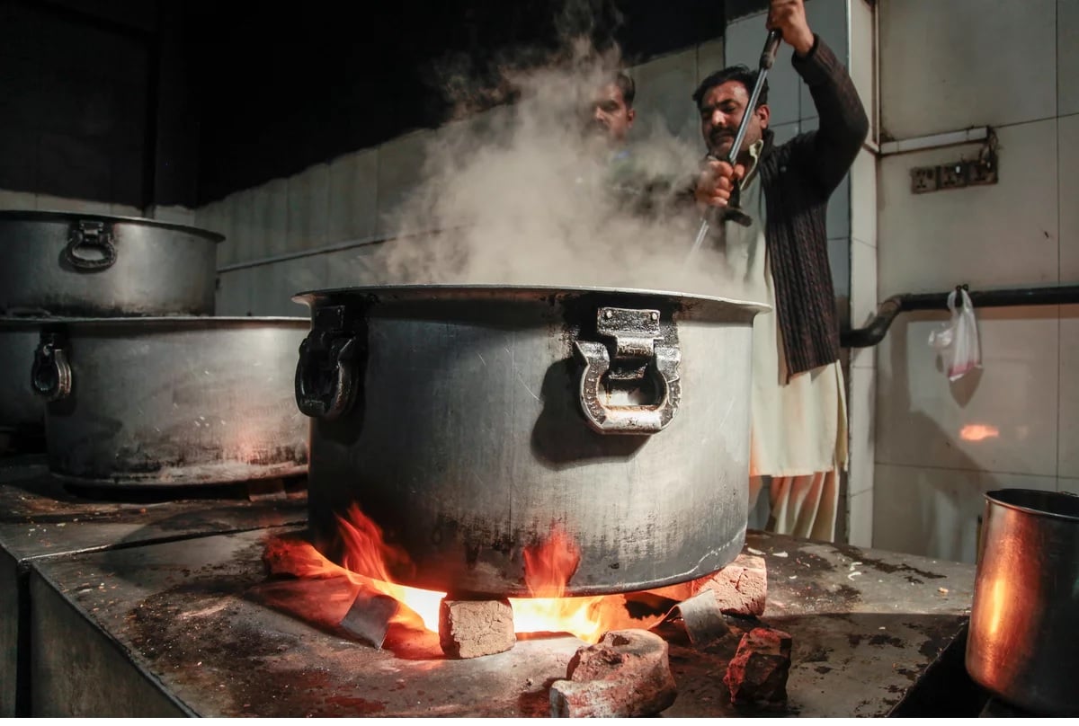A cook stirs a pot in the industrial kitchen on the ground floor of the Pakistani charity Saylani.— NPR