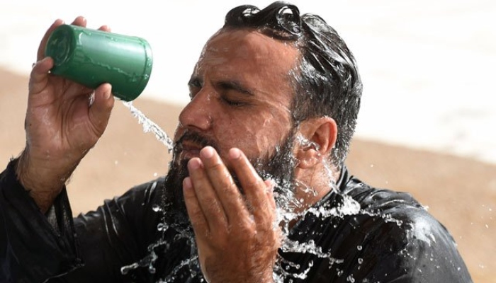 22 جون 2015 کو کراچی میں گرمی کی لہر کے دوران ایک شخص مسجد میں پانی سے ٹھنڈا کر رہا ہے۔ — اے ایف پی