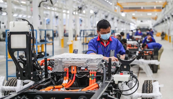 An employee working on a new energy vehicle assembly line at a BYD factory in Huaian in Chinas eastern Jiangsu province, July 6, 2020. AFP