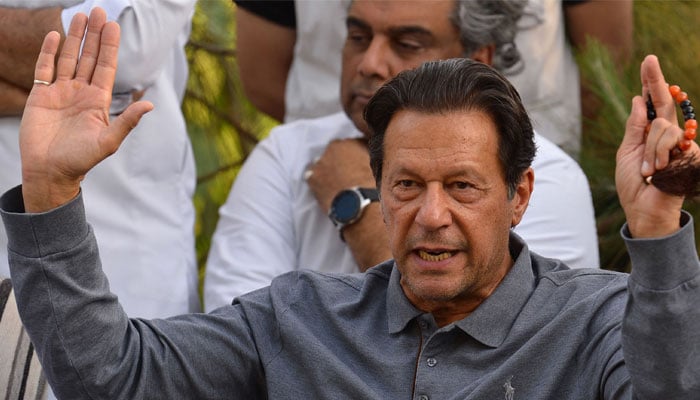 PTI Chairman Imran Khan raises his hands during a press conference in this undated photo. — AFP/File