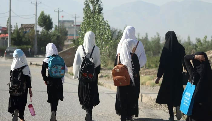 Girls in hijab walk to their school on September 8, 2022. — AFP