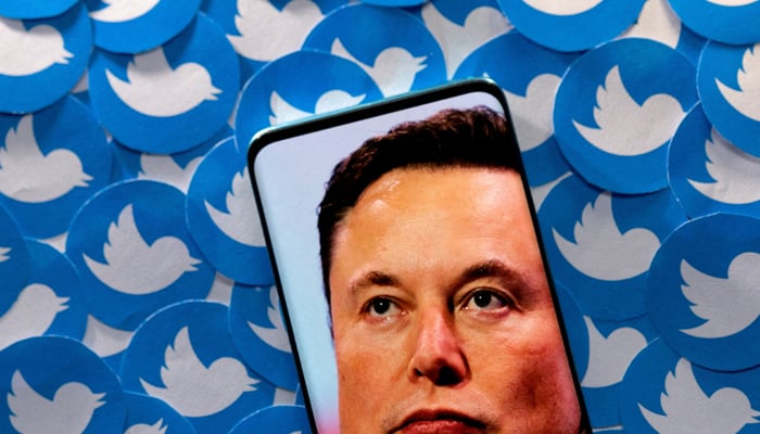 An image of Elon Musk is seen on a smartphone placed on printed Twitter logos in this picture illustration taken April 28, 2022. — Reuters