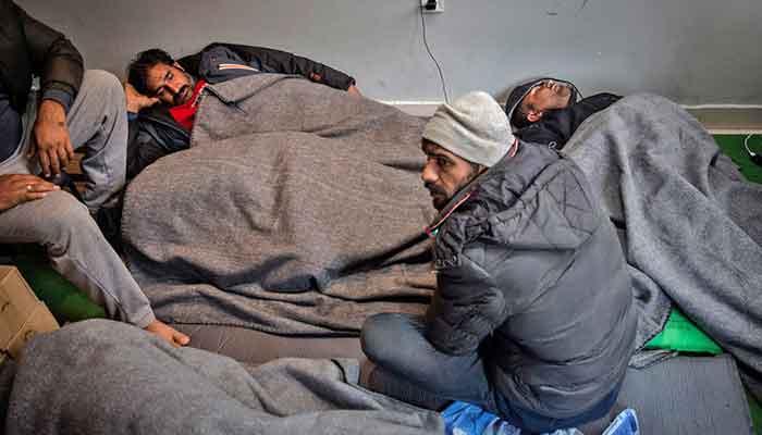 Migrants and refugees from Pakistan rest at a migrant center in Belgrade on March 14, 2018. — AFP