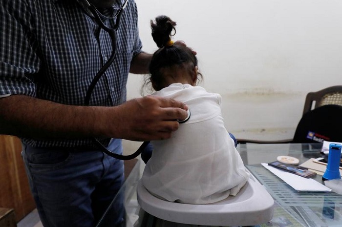 Seorang profesional kesehatan mendengarkan pernapasan seorang anak dengan stetoskop di sebuah klinik di pedesaan Sindh.  — Reuters/Berkas