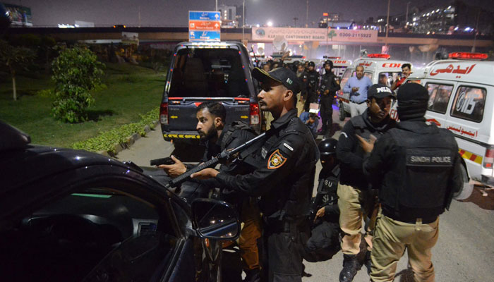 Police officers take position after a police office building was attacked by gunmen in Karachi. — AFP/File